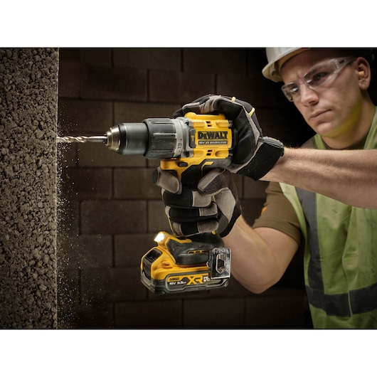 The 3.5Ah Powerstack battery on Drill Driver being used to drill through concrete frame