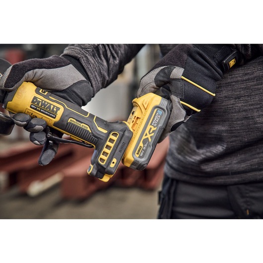 Powerstack battery being attached to the DEWALT 18V XR Compact 125mm Angle Grinder