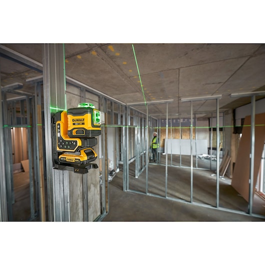 The DEWALT 18V 3X360 Remote Control Laser onsite attached to metal frame being controlled with remote by worker.