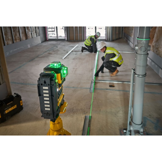 The DEWALT 18V 3X360 Remote Control Laser onsite on tripod being controlled with remote by workers.