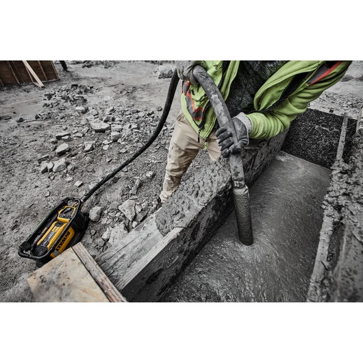 Construction worker using Powershift Powerpack Concrete Vibrator and hose