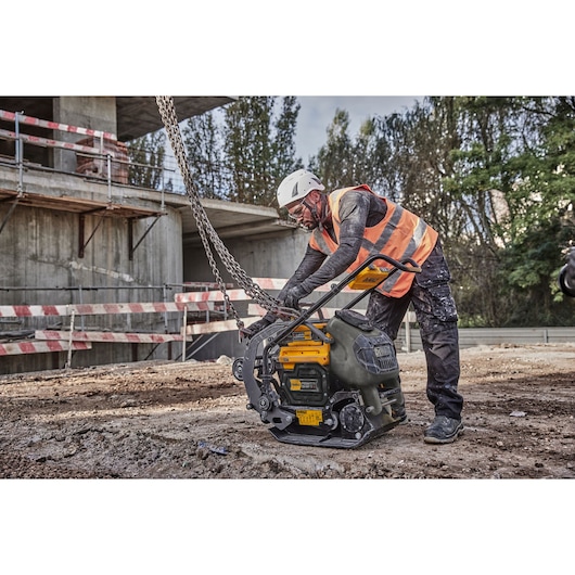 Worker attaches crane hook and chains to Powershift Plate Compactor