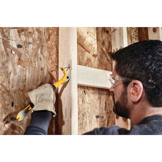 12 inch Precision Claw Bar being used by a person to pull nail from wood.